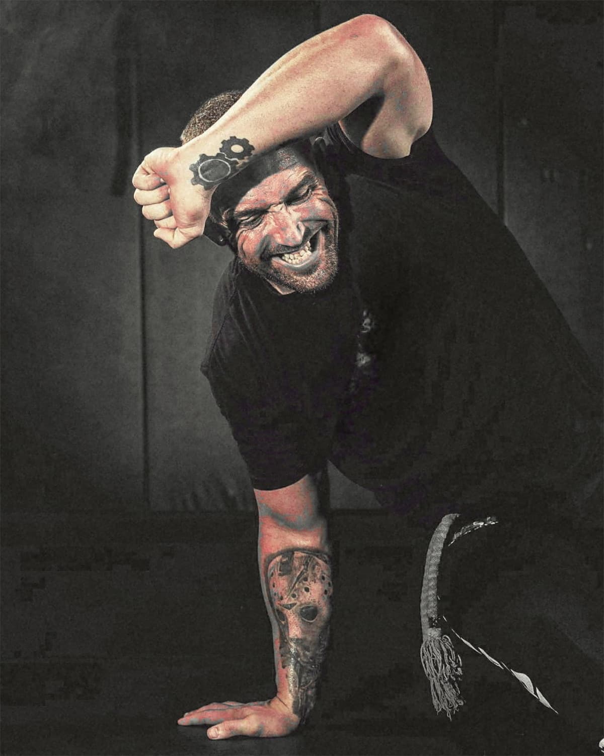 Professor Coringa Conway kneeling in a capoeira stance